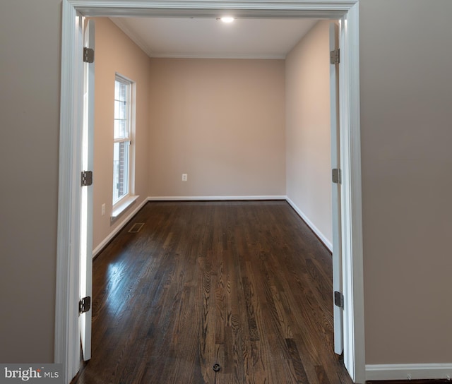 unfurnished room with ornamental molding and dark hardwood / wood-style flooring