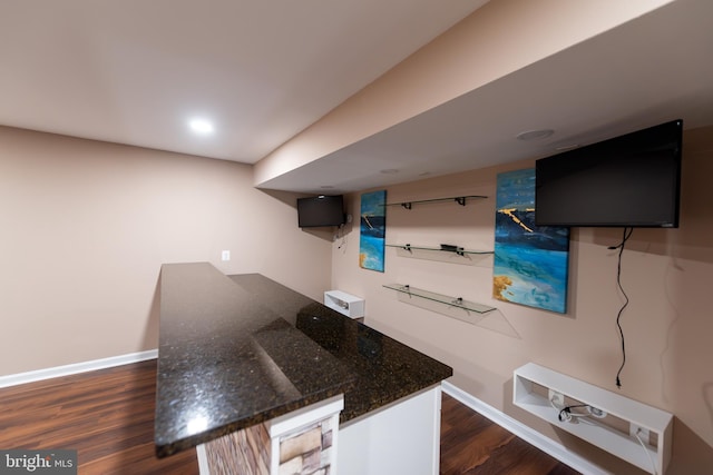 interior space featuring dark stone countertops and dark wood-type flooring