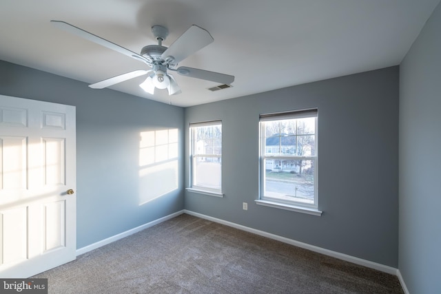 carpeted spare room featuring ceiling fan