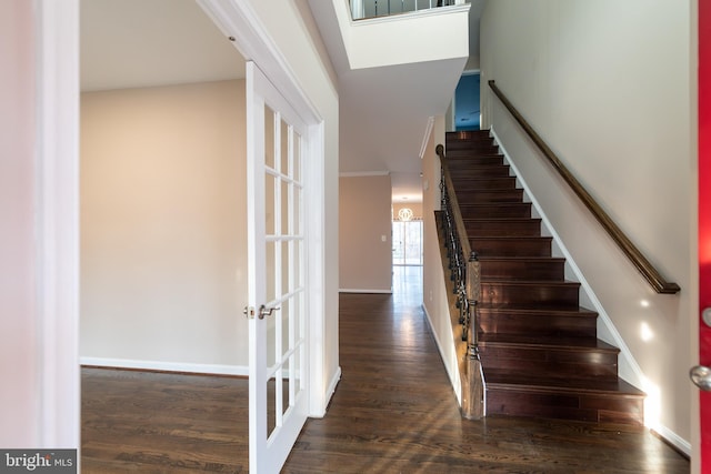 stairs featuring french doors, wood-type flooring, and crown molding