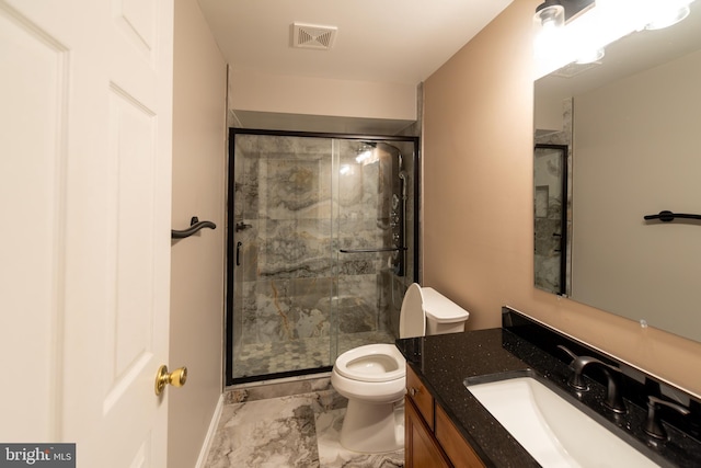 bathroom featuring an enclosed shower, vanity, and toilet