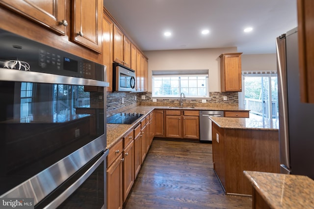 kitchen featuring tasteful backsplash, a healthy amount of sunlight, stainless steel appliances, and sink