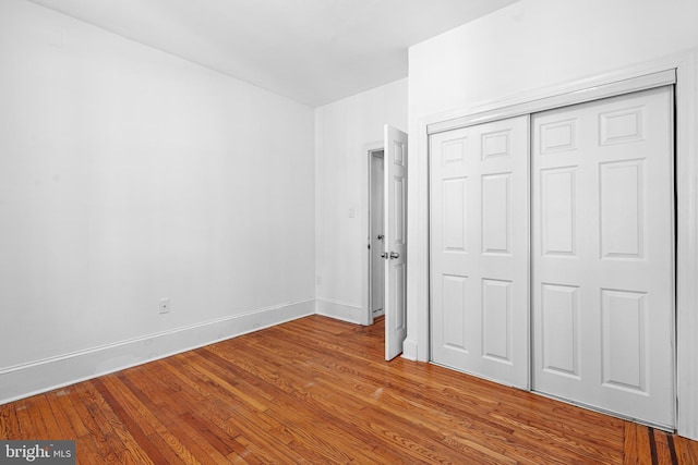 unfurnished bedroom featuring hardwood / wood-style floors and a closet