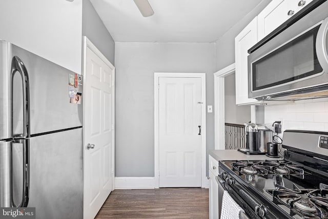 kitchen with appliances with stainless steel finishes, white cabinetry, dark hardwood / wood-style flooring, decorative backsplash, and ceiling fan