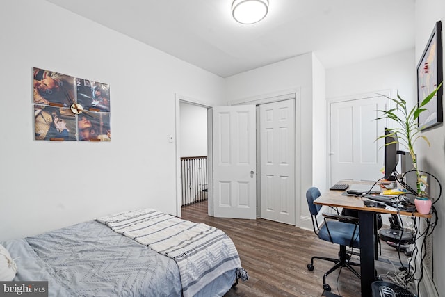 bedroom with dark hardwood / wood-style floors and a closet