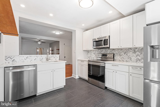 kitchen featuring white cabinetry, sink, stainless steel appliances, and ceiling fan