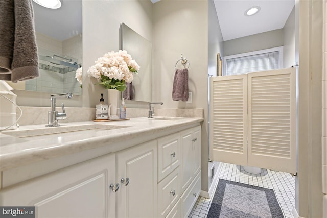 full bathroom featuring double vanity, an enclosed shower, tile patterned flooring, and a sink