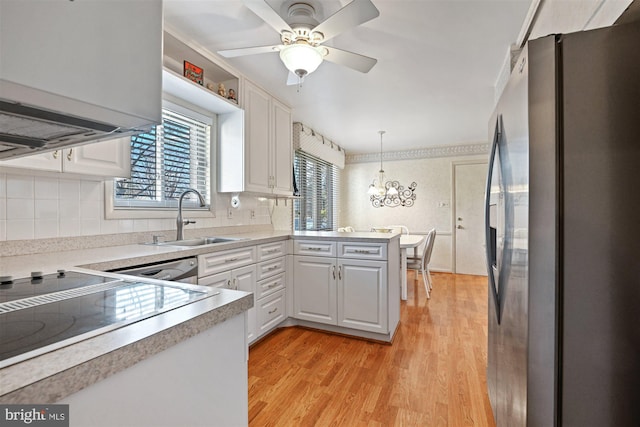 kitchen with a peninsula, white cabinetry, light countertops, appliances with stainless steel finishes, and pendant lighting