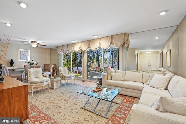 living area featuring light wood finished floors, a ceiling fan, and recessed lighting