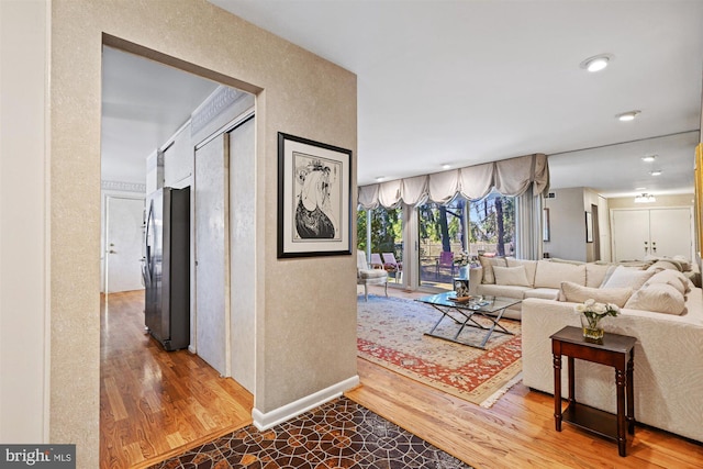 corridor featuring baseboards and wood finished floors