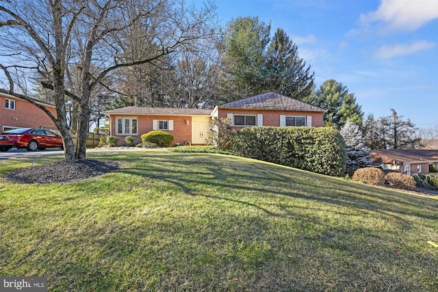 view of front of house with brick siding and a front yard