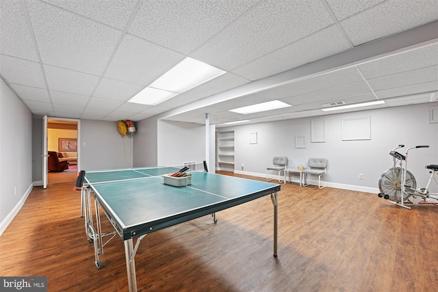 rec room featuring a paneled ceiling, baseboards, and wood finished floors