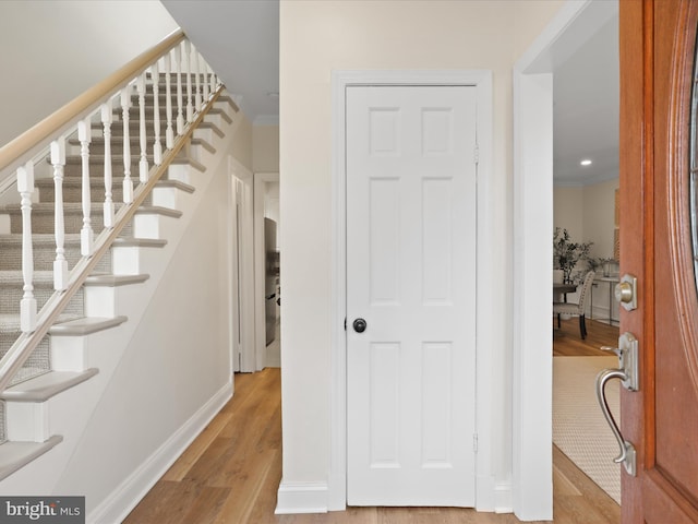 stairs featuring hardwood / wood-style flooring and crown molding