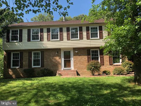 colonial-style house featuring a front yard