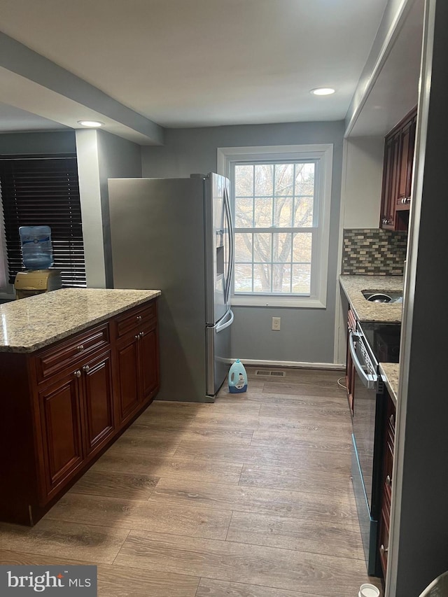 9429 Fairhaven Ave, Upper Marlboro, MD 20772 - kitchen featuring stainless steel fridge, electric range oven, backsplash, light stone countertops, and light wood-type flooring