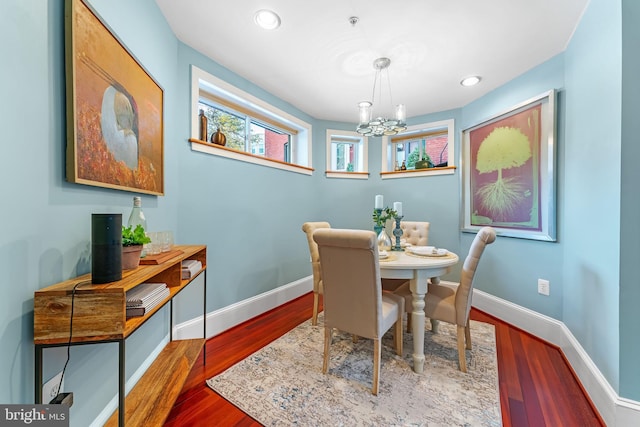 dining area with hardwood / wood-style floors and a chandelier