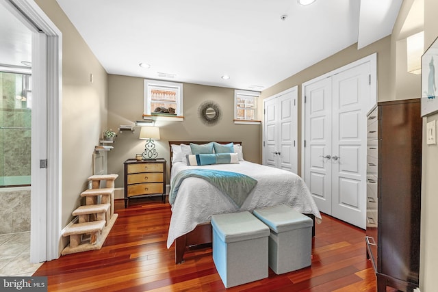 bedroom with multiple closets and dark hardwood / wood-style floors