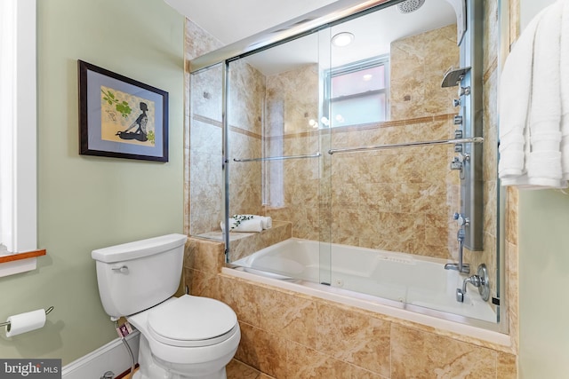 bathroom with bath / shower combo with glass door and toilet