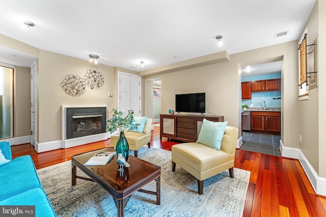 living room with sink and dark wood-type flooring