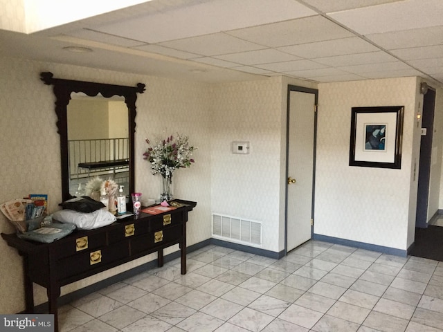 hallway with a paneled ceiling