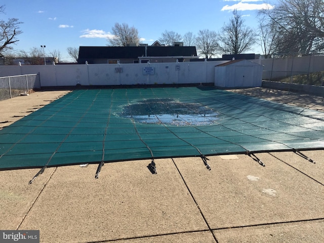 view of pool with a storage unit and a patio