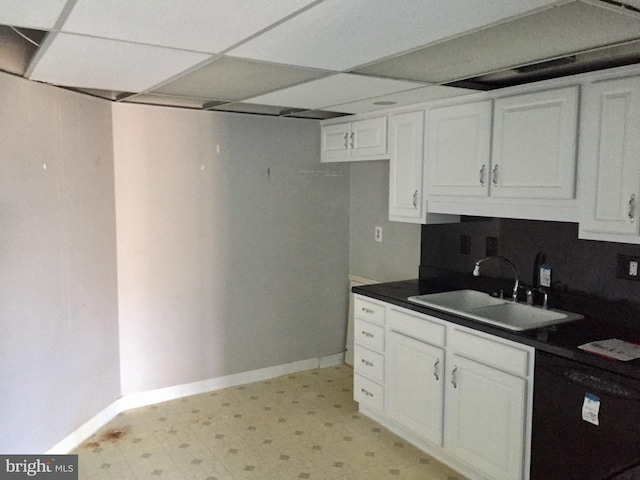 kitchen with a paneled ceiling, white cabinetry, dishwasher, and sink