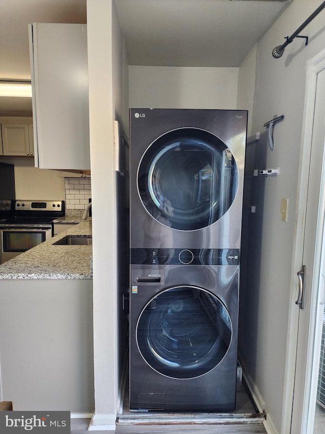 laundry room with sink and stacked washer and clothes dryer