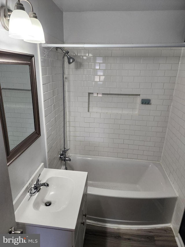 bathroom featuring tiled shower / bath combo and vanity