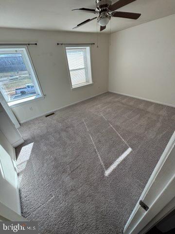 empty room with ceiling fan and carpet