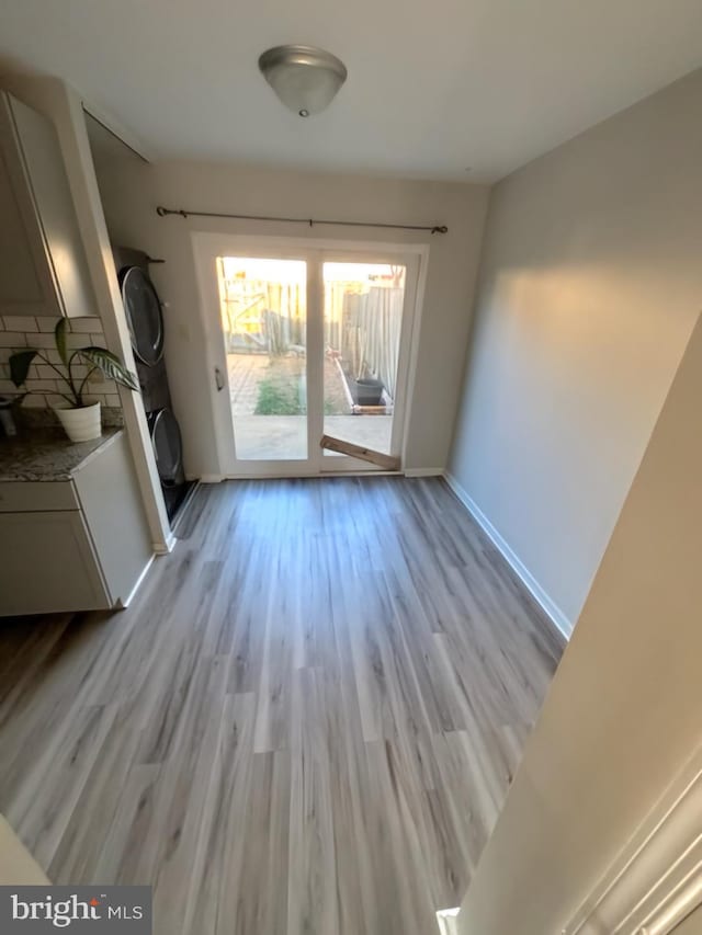 interior space featuring stacked washer / dryer and light hardwood / wood-style floors