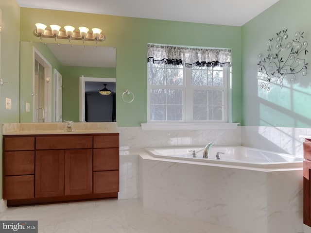 bathroom featuring vanity and a relaxing tiled tub