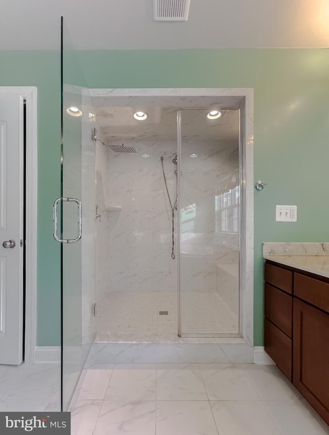 bathroom featuring walk in shower and vanity