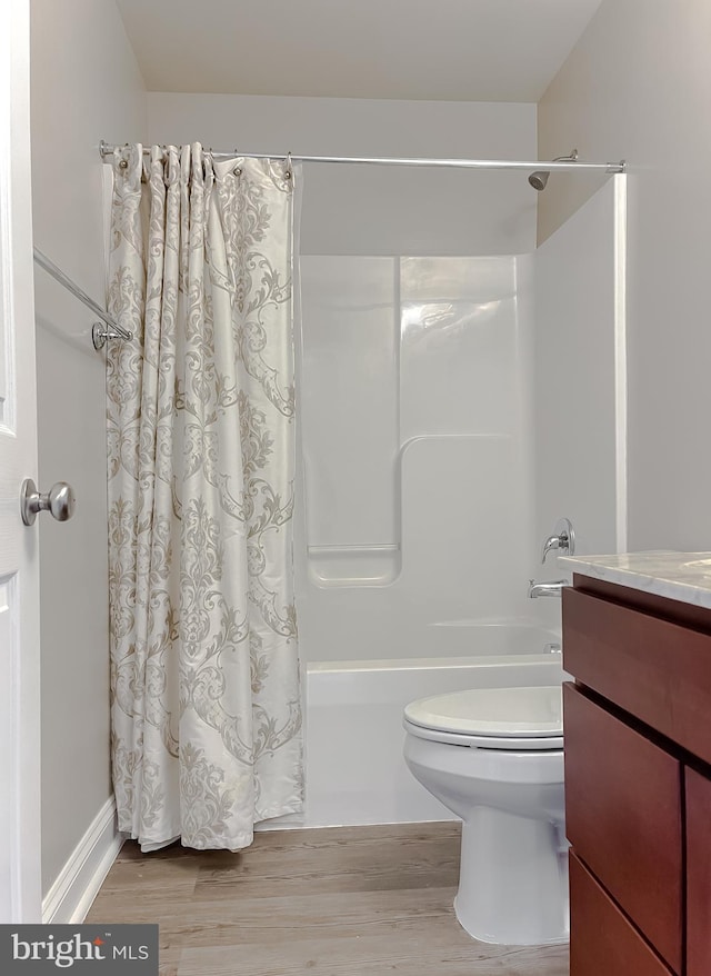 full bathroom featuring toilet, shower / bathtub combination with curtain, wood-type flooring, and vanity