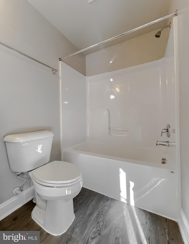 bathroom featuring toilet, wood-type flooring, and  shower combination