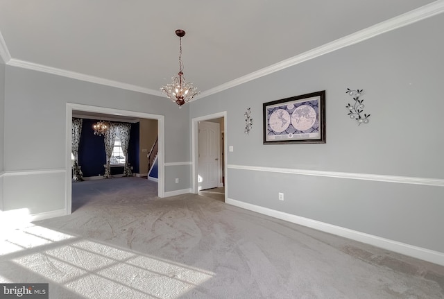 carpeted empty room featuring crown molding and a chandelier