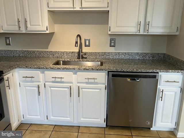 kitchen with light tile patterned floors, dishwasher, and white cabinetry