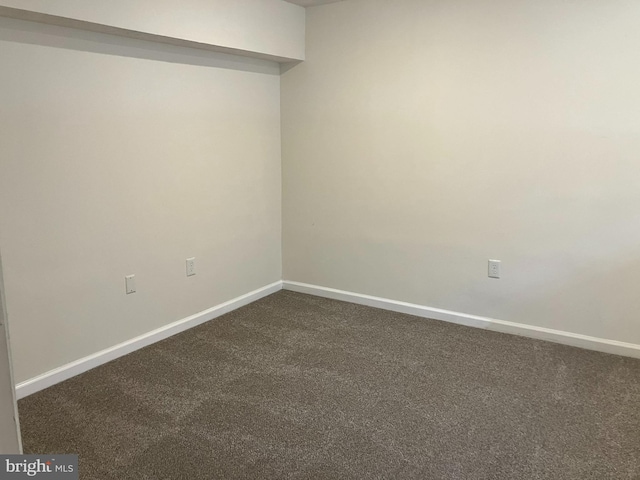 unfurnished room with dark carpet