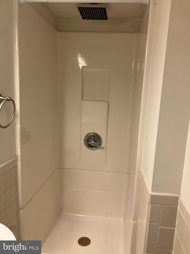 bathroom featuring tile walls and walk in shower