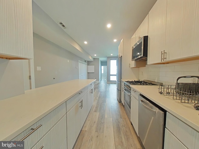 kitchen with tasteful backsplash, light wood-type flooring, and stainless steel appliances