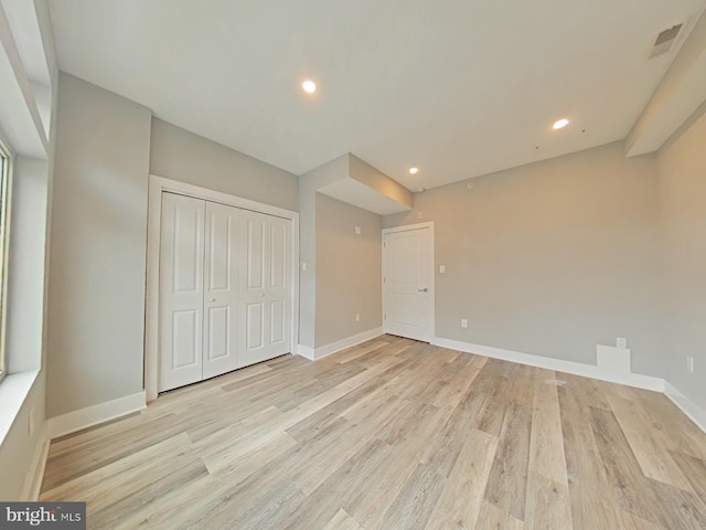 unfurnished bedroom featuring a closet and light hardwood / wood-style floors