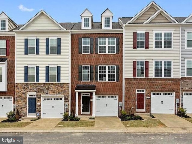 townhome / multi-family property with brick siding, driveway, and an attached garage