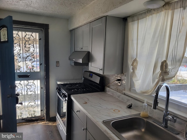 kitchen featuring stainless steel range with gas stovetop, plenty of natural light, extractor fan, and sink