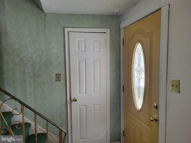 foyer entrance with a textured ceiling