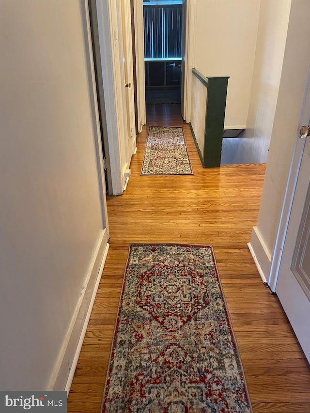 hallway with hardwood / wood-style floors