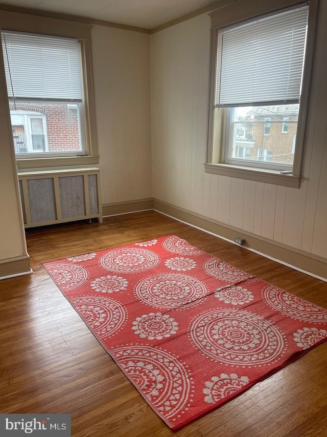 unfurnished room with crown molding, radiator heating unit, and light hardwood / wood-style floors