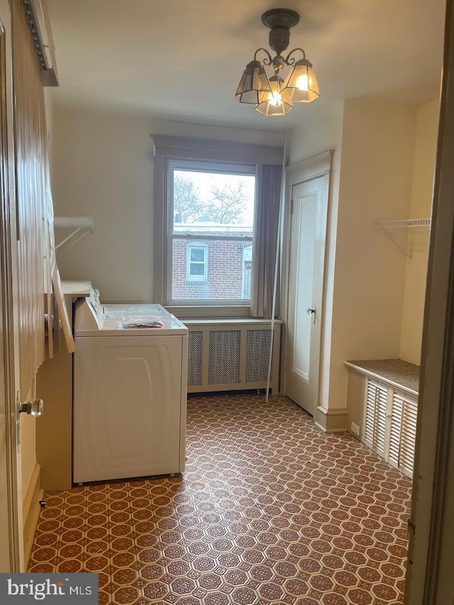 laundry area with washer / clothes dryer, radiator, and an inviting chandelier