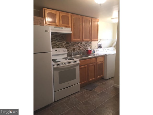 kitchen featuring washer and dryer, sink, white appliances, and decorative backsplash