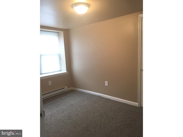 carpeted spare room with a baseboard radiator