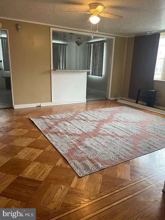 spare room featuring crown molding, parquet floors, ceiling fan, and a textured ceiling