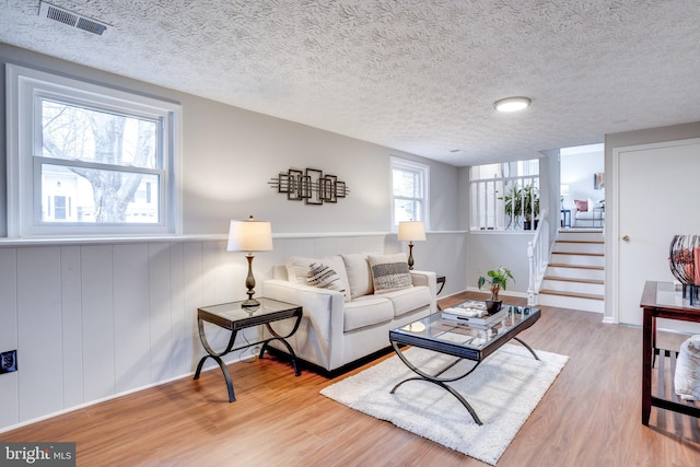 living room with light hardwood / wood-style floors and a textured ceiling